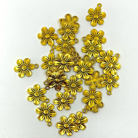 Gold colored flower charms are scattered across a white background.